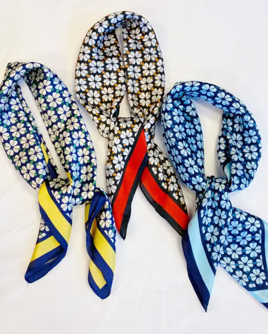 Three floral patterned scarves with colorful ends on a white background