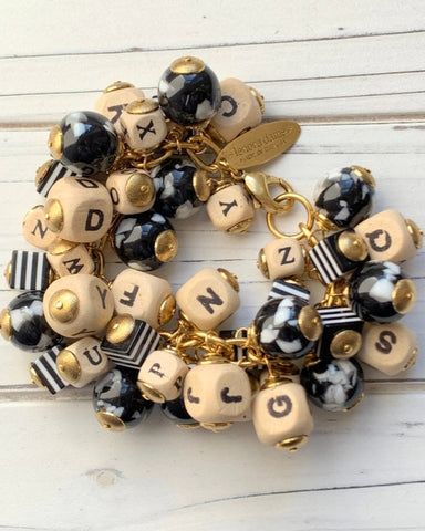 Bracelet with letter beads and gold accents on a white wooden surface