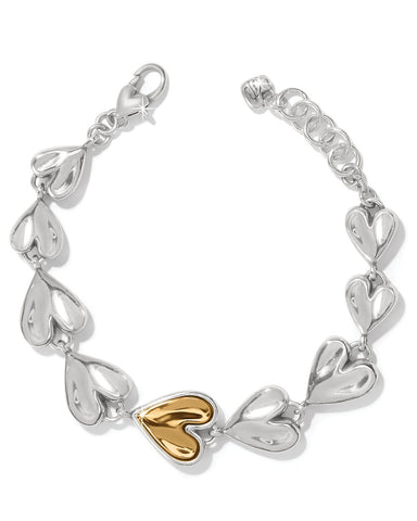 Silver bracelet with a gold heart charm on a white background